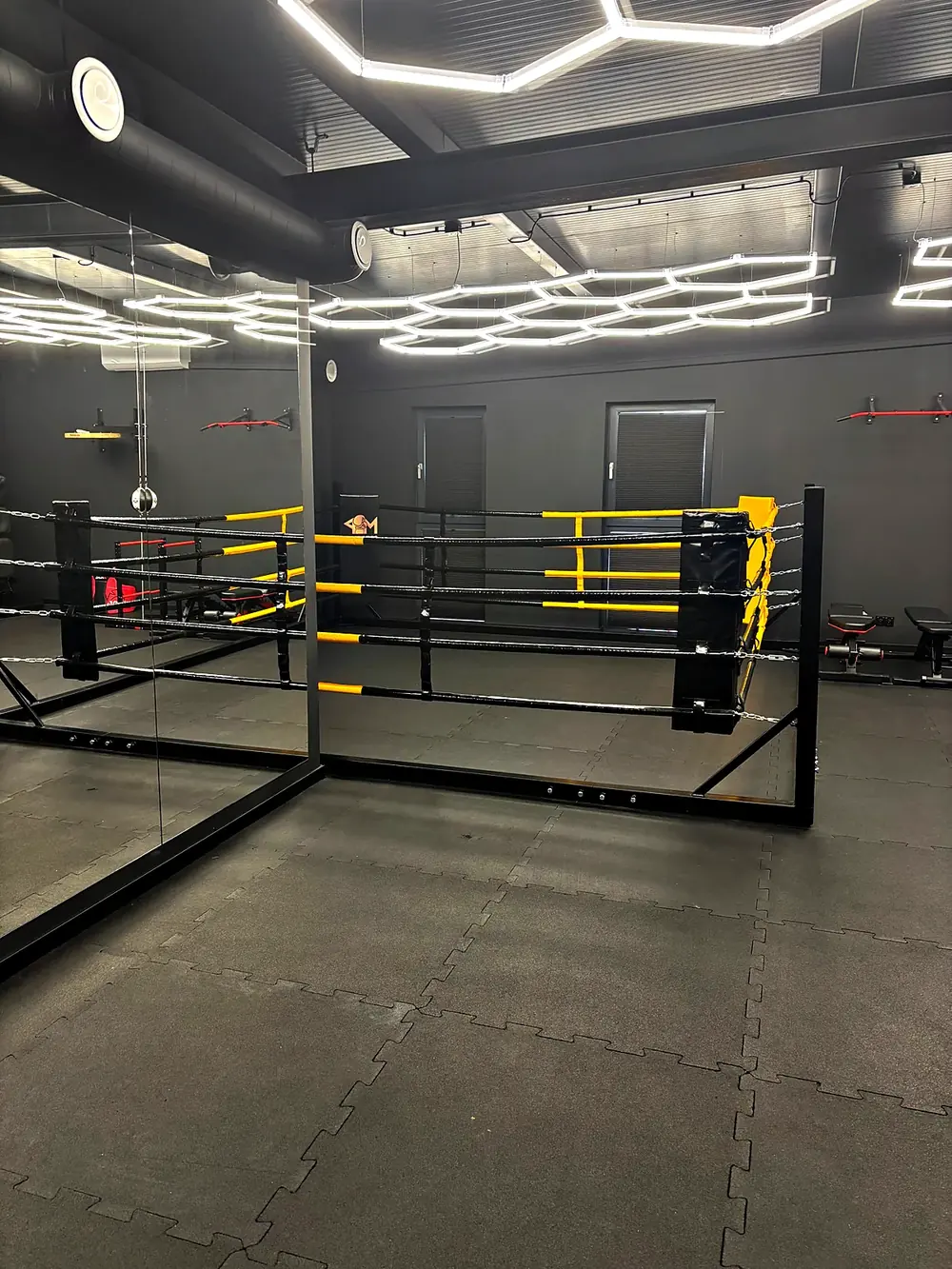 Ring treningowy, lustra i worki bokserskie w sali PM Boxing Studio
