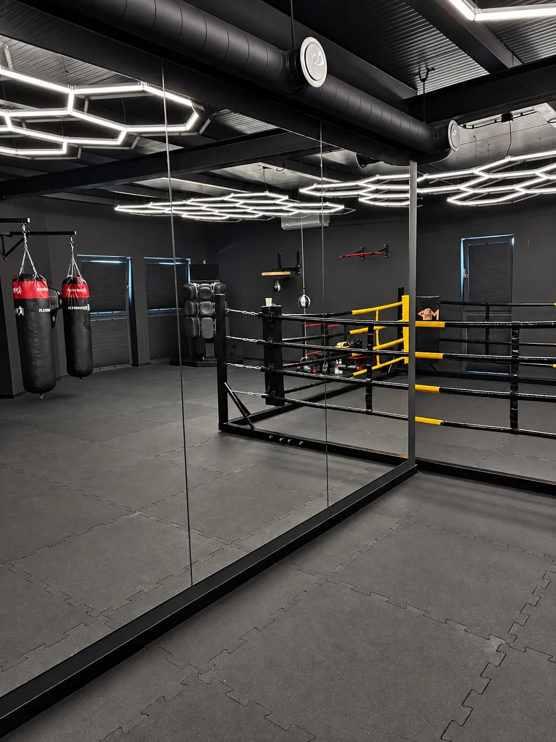 Duże lustra, ring i worki bokserskie w sali PM Boxing Studio